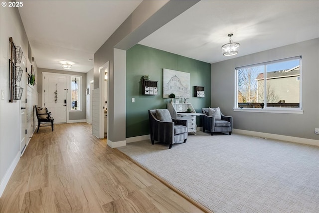 living area with light wood-type flooring and a chandelier