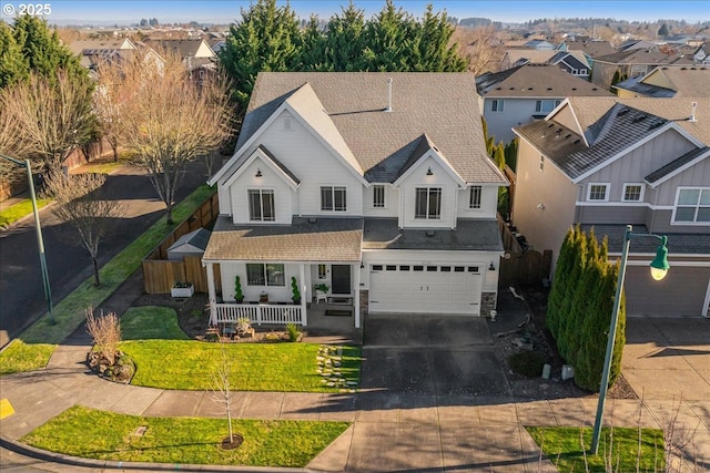 view of front of property with covered porch, a garage, and a front lawn