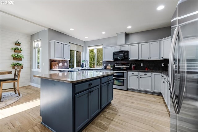 kitchen featuring a kitchen island, light hardwood / wood-style floors, white cabinetry, and stainless steel appliances