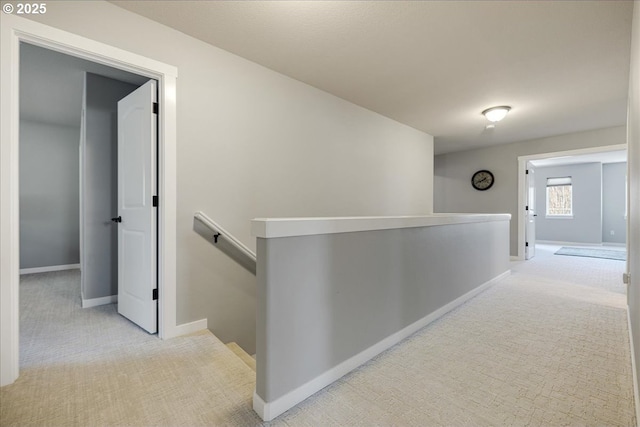 hallway featuring light colored carpet