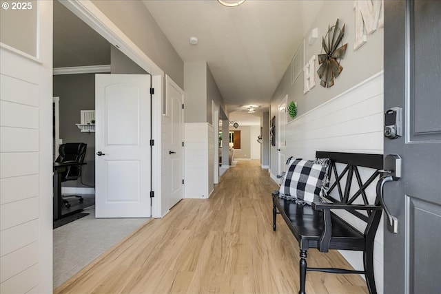 hallway featuring light hardwood / wood-style flooring and ornamental molding