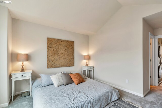 carpeted bedroom with baseboards and lofted ceiling