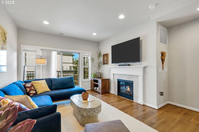living area featuring recessed lighting, visible vents, baseboards, and wood finished floors