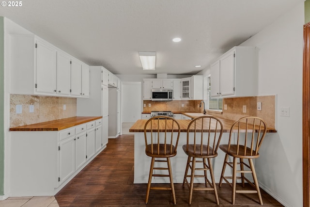 4720 NE 124th Ct, Vancouver, WA 98682 - kitchen with appliances with stainless steel finishes, a peninsula, decorative backsplash, recessed lighting, and white cabinets