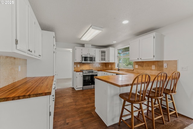 4720 NE 124th Ct, Vancouver, WA 98682 - kitchen featuring appliances with stainless steel finishes, a peninsula, wood counters, dark wood-style floors, and recessed lighting