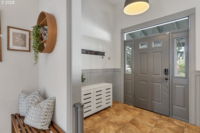 entrance foyer featuring a wainscoted wall and light tile patterned floors