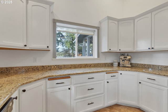 kitchen with white cabinetry, light stone counters, and dishwasher