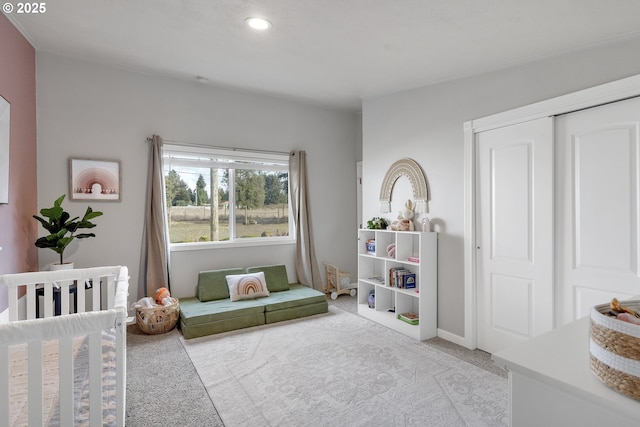 bedroom featuring carpet floors, baseboards, and a crib