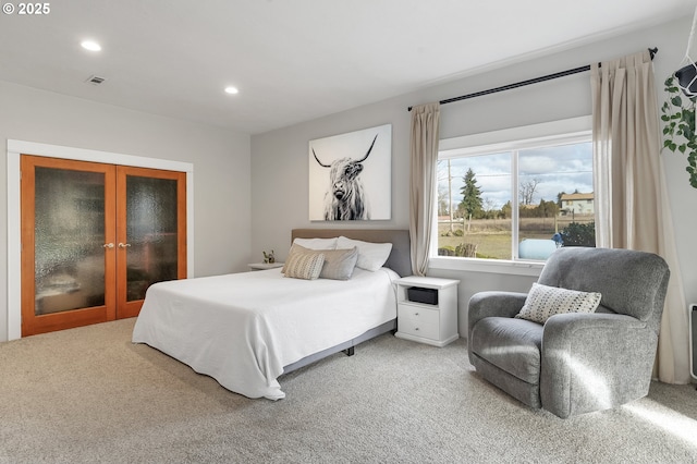 carpeted bedroom with recessed lighting, visible vents, and french doors