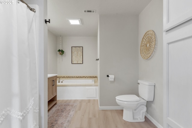 full bath with a garden tub, toilet, wood finished floors, visible vents, and baseboards