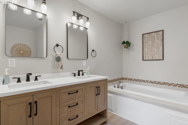 bathroom with double vanity, a sink, and a bath