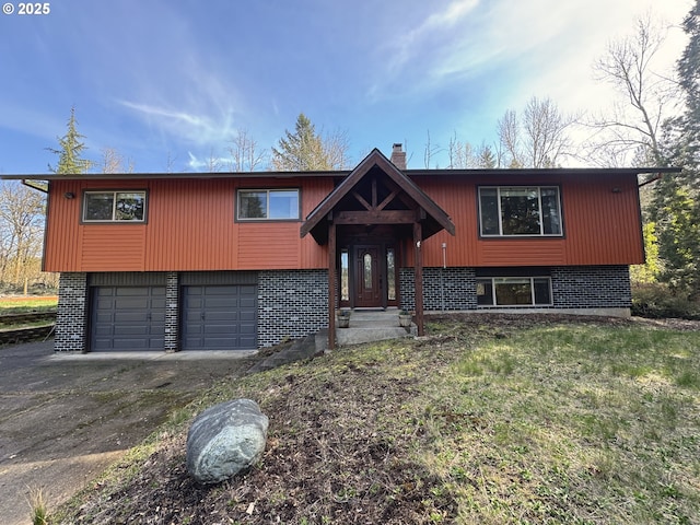 15400 SE Barlow Ct, Damascus, OR 97089 - split foyer home with asphalt driveway, a garage, brick siding, and a chimney