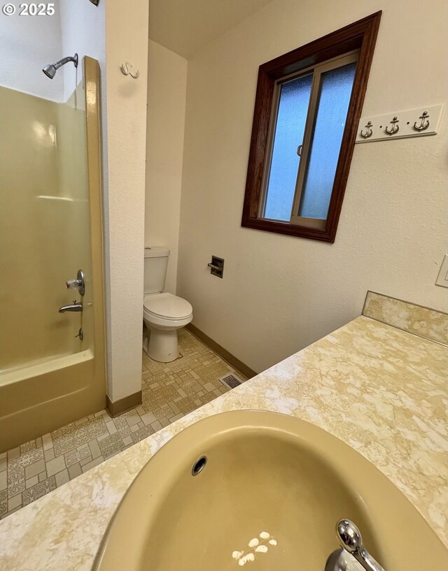 bathroom featuring baseboards, tiled shower, vanity, and wood finish floors