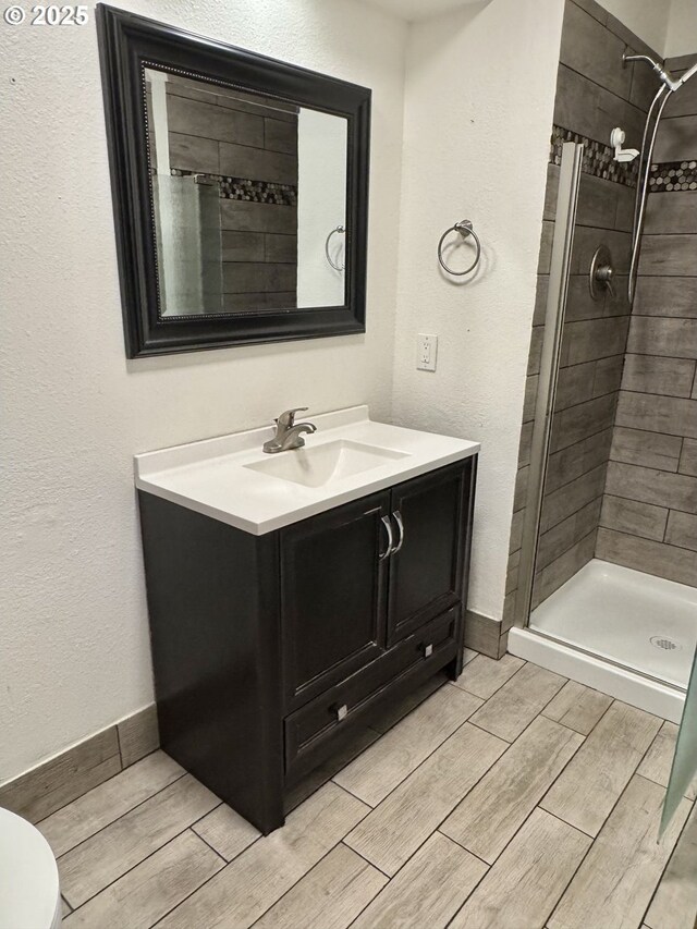 spare room with visible vents, a textured ceiling, baseboards, and wood finished floors