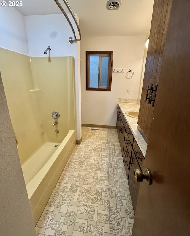 bathroom with vanity, baseboards, visible vents, and shower / bath combination