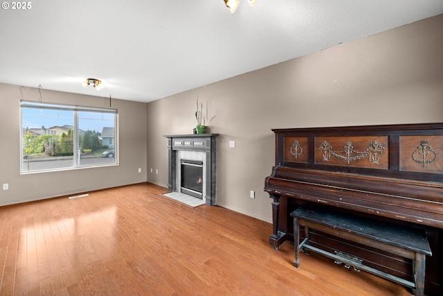 living area featuring baseboards, a fireplace, and wood finished floors