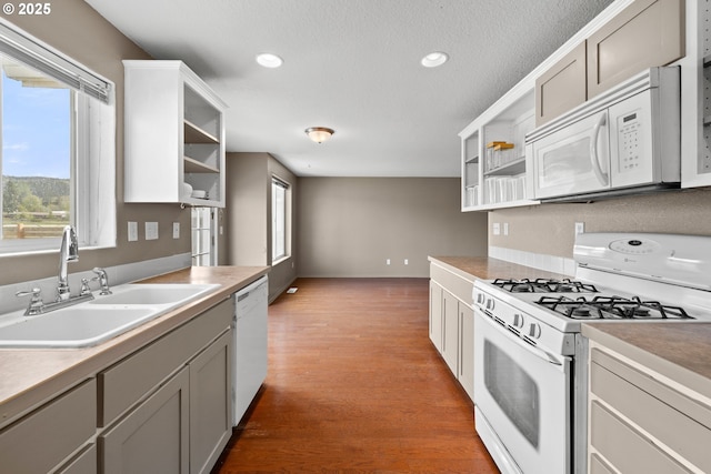 kitchen with recessed lighting, white appliances, dark wood finished floors, a sink, and open shelves