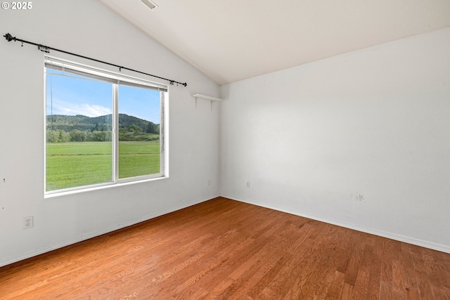 unfurnished room with lofted ceiling, baseboards, and light wood-type flooring