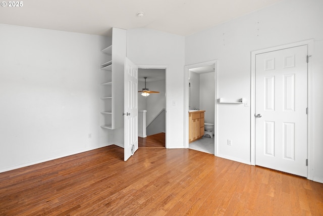 unfurnished bedroom featuring ensuite bathroom, light wood-type flooring, and baseboards