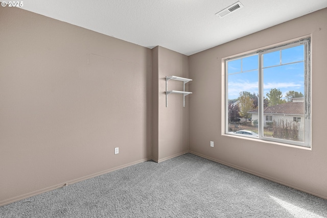 carpeted empty room with visible vents and baseboards