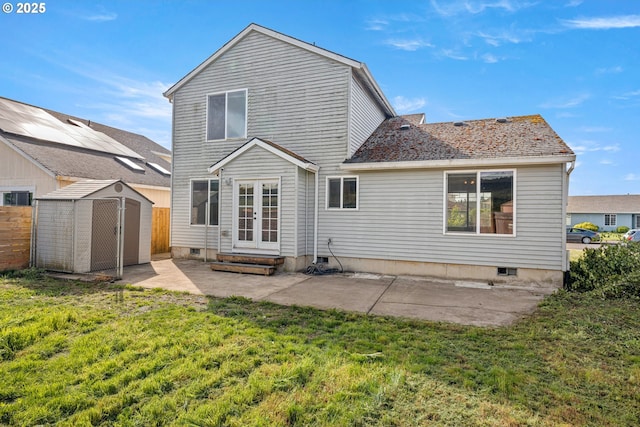 back of house with fence, a storage shed, an outdoor structure, a patio, and a lawn