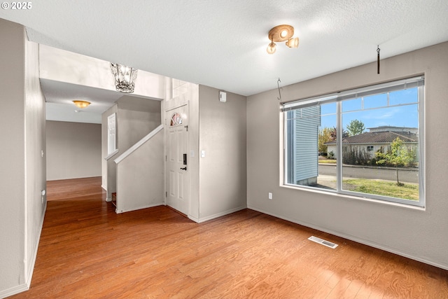 unfurnished room featuring light wood finished floors, baseboards, and visible vents