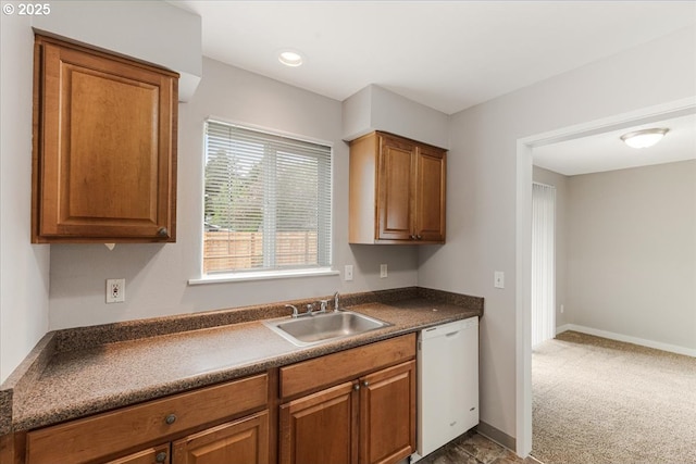 911 W Charles St, Newberg, OR 97132 - kitchen featuring white dishwasher, dark countertops, a sink, and brown cabinetry