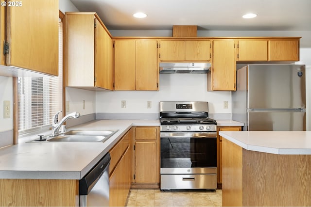 kitchen featuring stainless steel appliances, light countertops, a sink, and under cabinet range hood