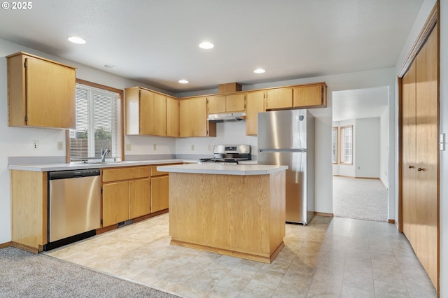 kitchen with a healthy amount of sunlight, under cabinet range hood, appliances with stainless steel finishes, and light countertops