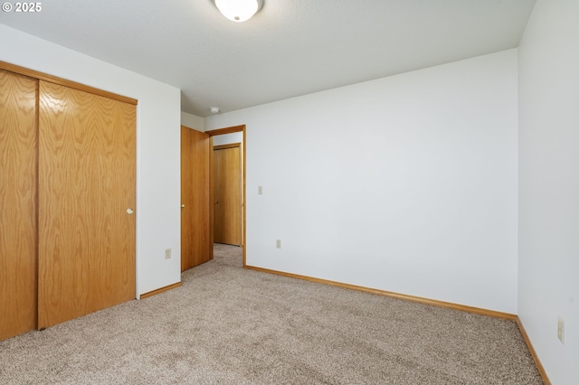 unfurnished bedroom featuring carpet, a closet, and baseboards