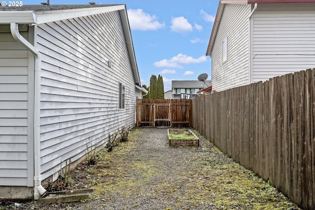 view of property exterior with a garden and a fenced backyard