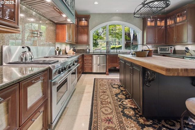 1500 SE Waverly Dr, Milwaukie, OR 97222 - kitchen with wooden counters, stainless steel appliances, ventilation hood, recessed lighting, and tasteful backsplash