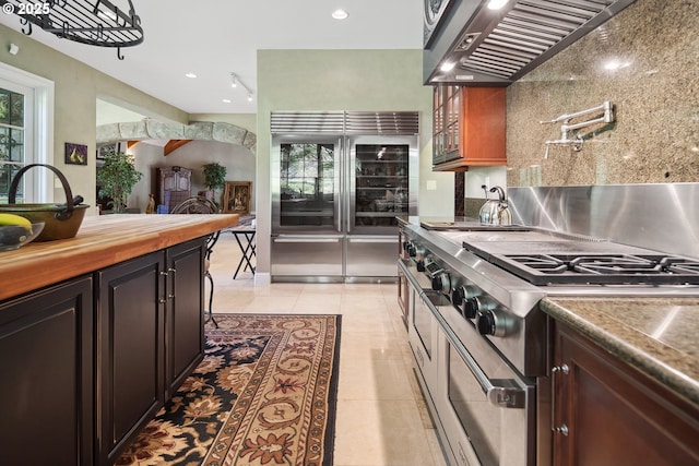 1500 SE Waverly Dr, Milwaukie, OR 97222 - kitchen featuring premium appliances, ventilation hood, tasteful backsplash, light tile patterned flooring, and plenty of natural light