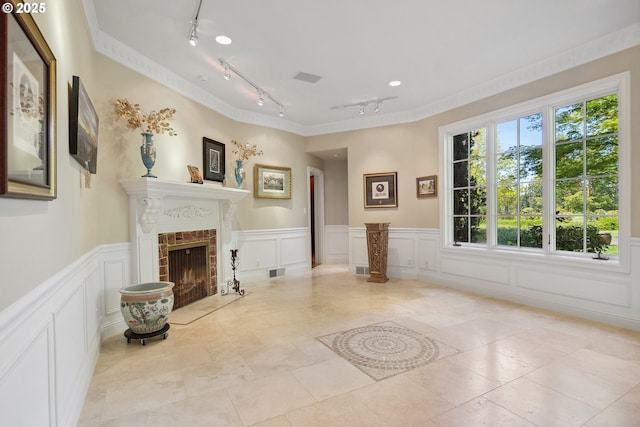 1500 SE Waverly Dr, Milwaukie, OR 97222 - living room featuring rail lighting, a decorative wall, a wainscoted wall, a fireplace, and crown molding