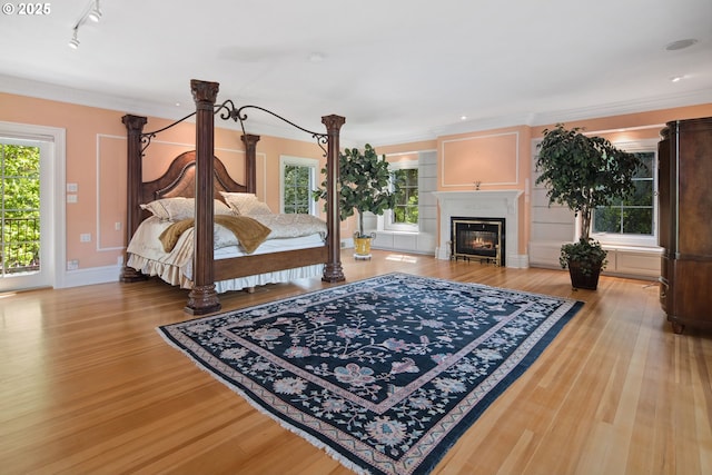 1500 SE Waverly Dr, Milwaukie, OR 97222 - bedroom with light wood finished floors, a glass covered fireplace, ornamental molding, track lighting, and baseboards