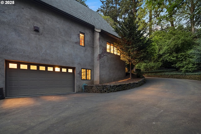 1500 SE Waverly Dr, Milwaukie, OR 97222 - view of home's exterior featuring stucco siding, asphalt driveway, and a garage