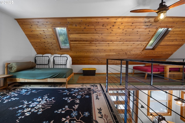 living area with lofted ceiling with skylight, ceiling fan, and wood-type flooring