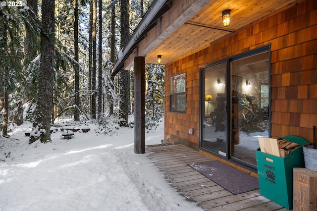 snow covered property entrance with a deck