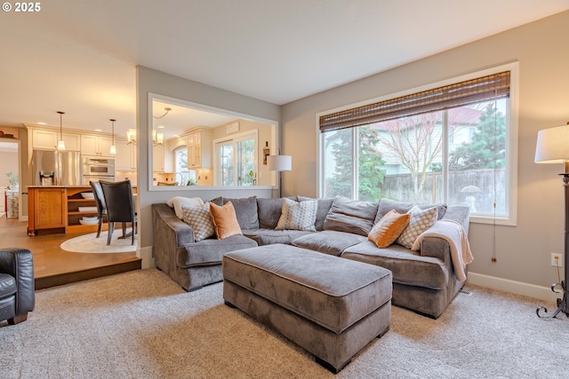 carpeted living room featuring a notable chandelier