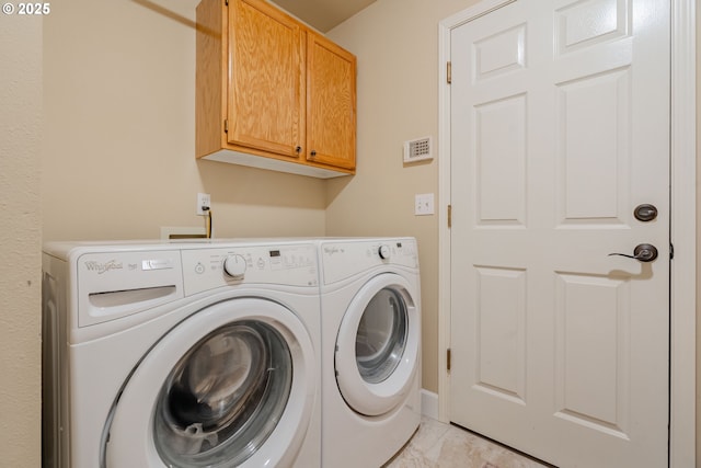 washroom with separate washer and dryer and cabinets