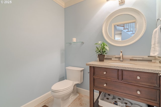 bathroom with vanity, ornamental molding, and toilet