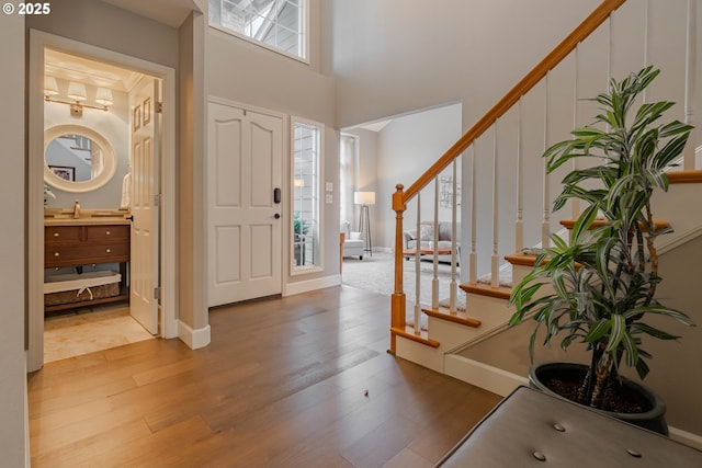 foyer entrance featuring a towering ceiling and hardwood / wood-style floors