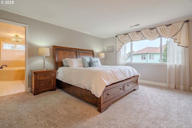 carpeted bedroom with ornamental molding and connected bathroom