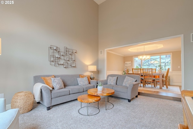 living room featuring an inviting chandelier, crown molding, and a high ceiling