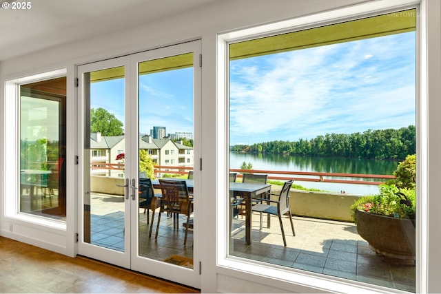 entryway with a water view, plenty of natural light, and french doors