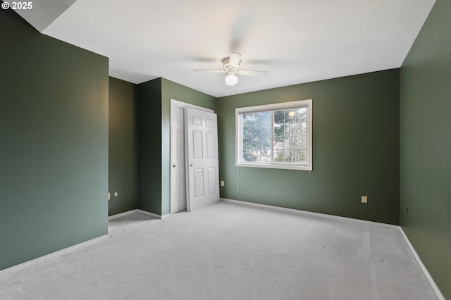 unfurnished bedroom with light colored carpet, ceiling fan, and a closet