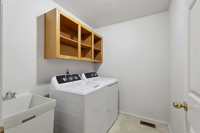 washroom with sink and independent washer and dryer