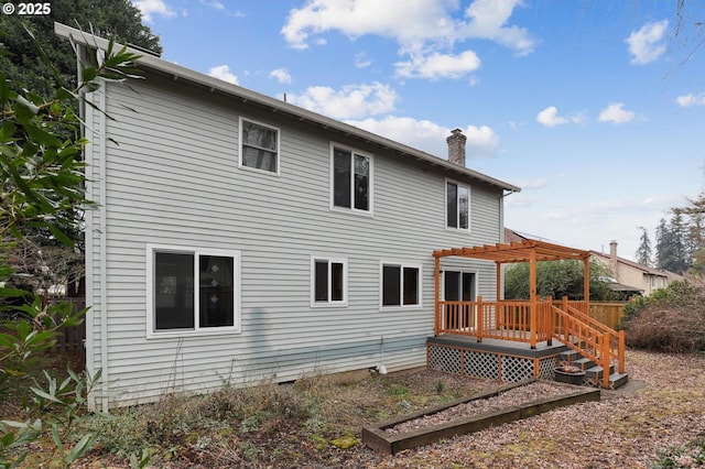 rear view of property with a deck and a pergola