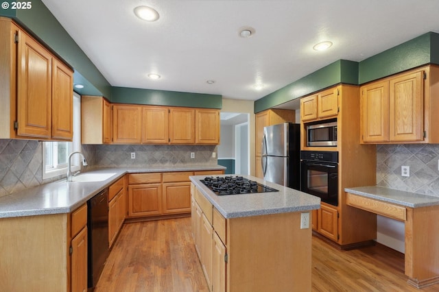 kitchen featuring sink, a center island, light hardwood / wood-style floors, decorative backsplash, and black appliances