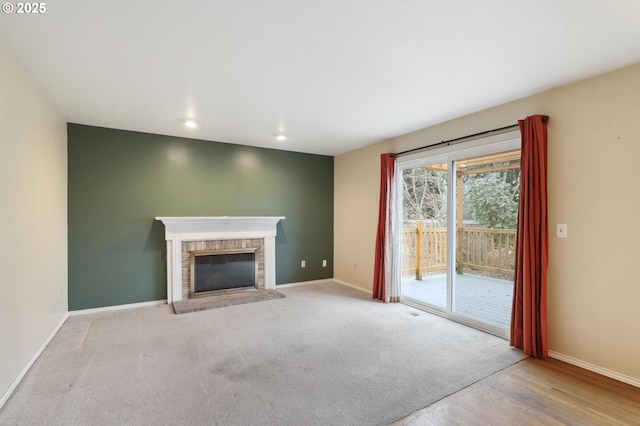 unfurnished living room featuring light colored carpet and a fireplace